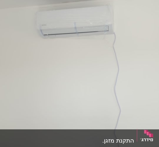 מזגן מותקן על קיר עם סולם לידו